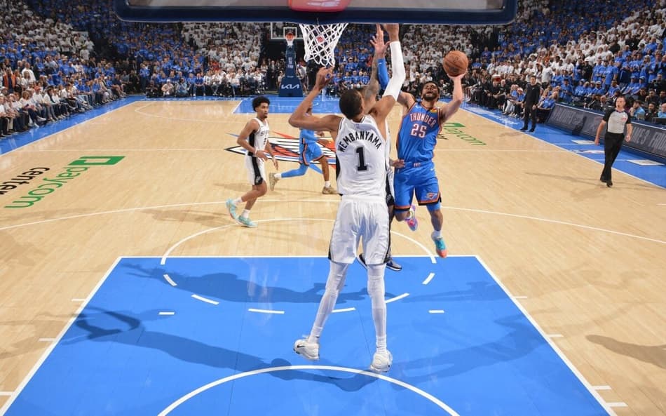 Ajay Mitchell, do Oklahoma City Thunder, recebe a marcação de Victor Wembanyama, do San Antonio Spurs (Foto: Jesse D. Garrabrant/NBAE via Getty Images/AFP)