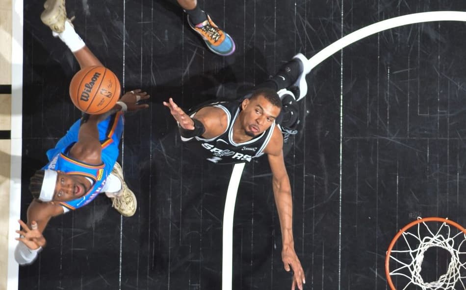 Shai Gilgeous-Alexander, do Oklahoma, disputa a bola com Victor Wembanyama. do San Antonio Spurs (Foto: Michael Gonzales / NBAE Getty Images via AFP)