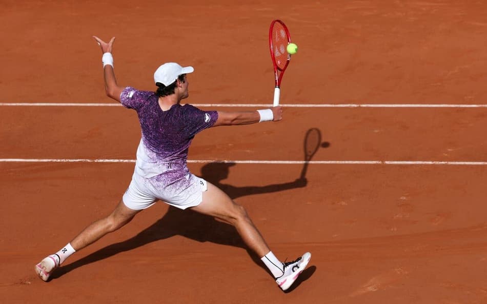 João Fonseca voleia na estreia de Roland Garros contra o francês Luka Pavlovic (Foto: Alain JOCARD / AFP)