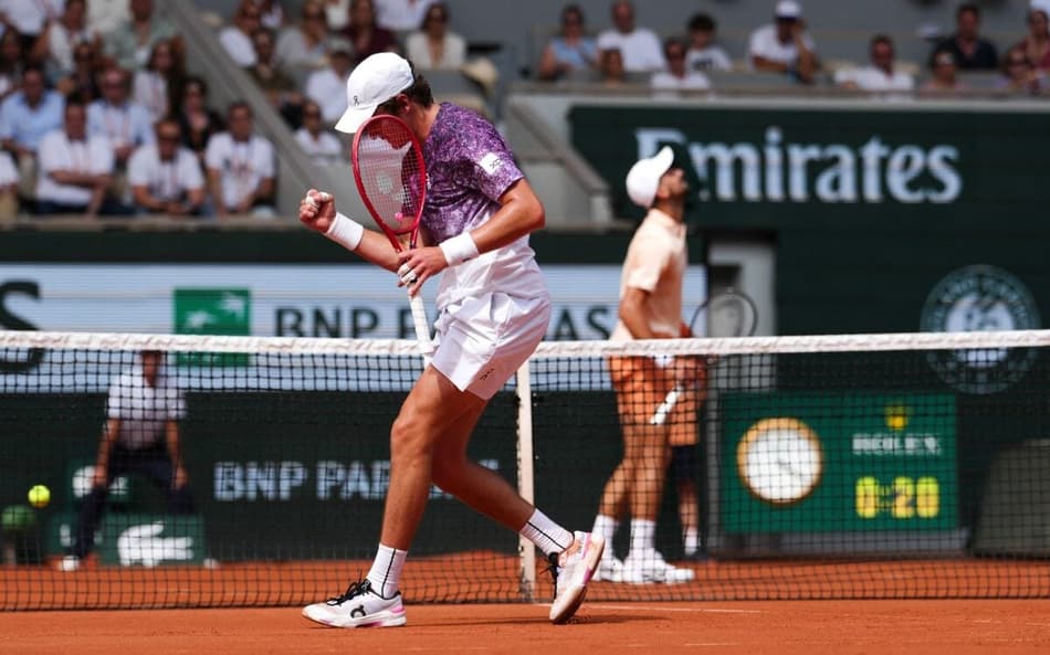 João Fonseca comemora ponto contra o sérvio Novak Djokovic (Foto: Dimitar DILKOFF / AFP)