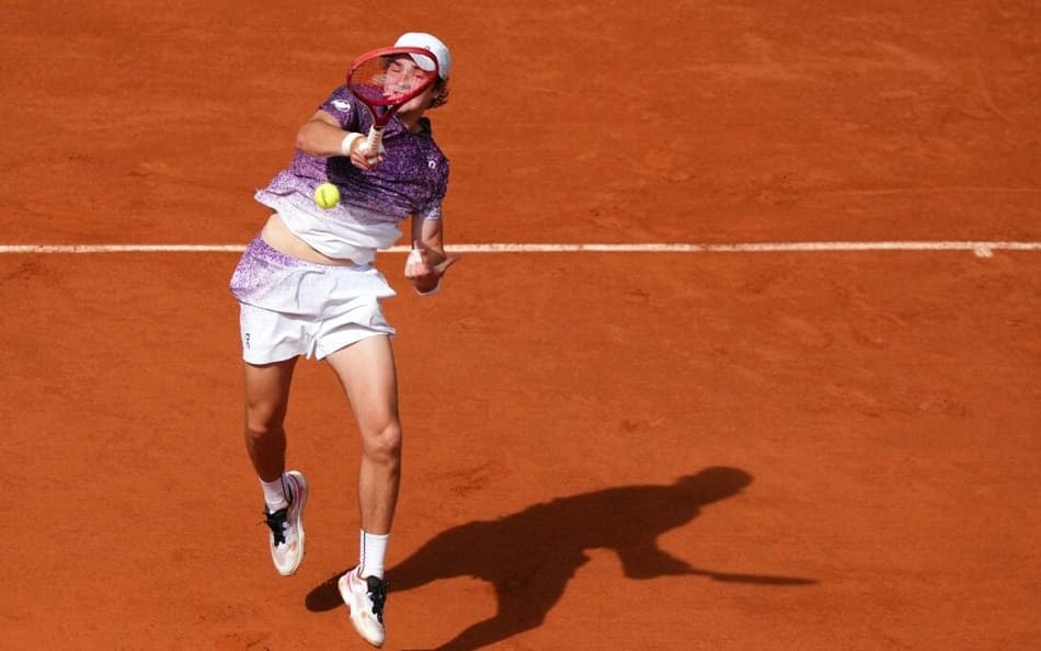 João Fonseca devolve de direita na partida contra o sérvio Novak Djokovic (Foto: Dimitar DILKOFF / AFP)
