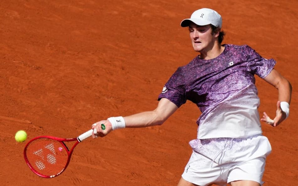 João Fonseca devolve de direita na partida contra o sérvio Novak Djokovic (Foto: Dimitar DILKOFF / AFP)