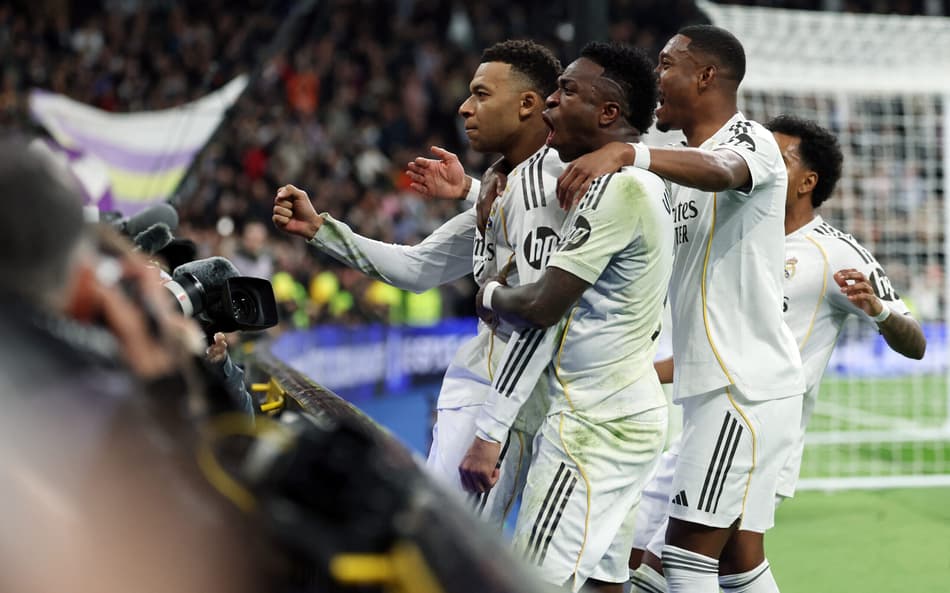 Alaba e Vini Jr comemorando o gol de Mbappé, na vitória do Real Madrid sobre o Rayo Vallecano (Foto: Thomas Coex/AFP)
