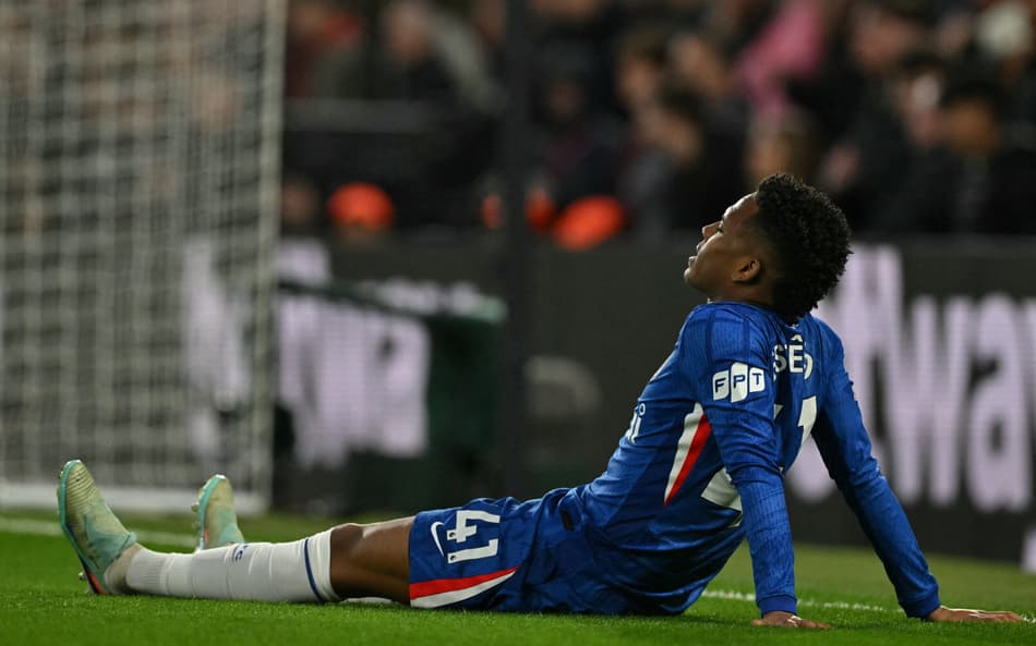 Estêvão caído no gramado após sentir lesão muscular na derrota do Chelsea para o Manchester United, na Premier League