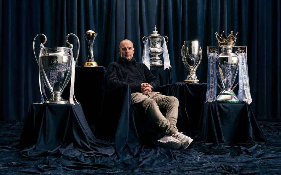 Pep Guardiola ao lado dos diferentes troféus conquistados com o Manchester City