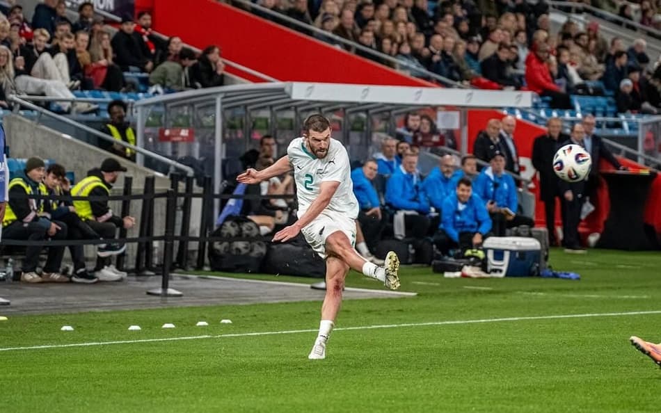 Zagueiro Tim Payne finaliza com a perna direita, que está suspensa no ar, e a bola flutua a sua frente
