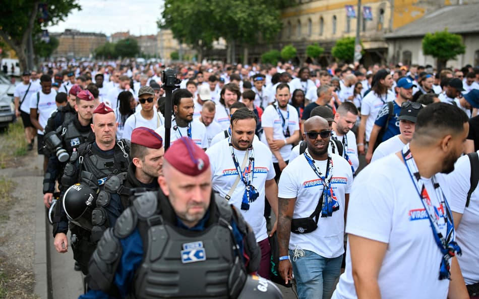 Torcedores do PSG escoltados pela polícia antes da final da Champions League contra o Arsenal