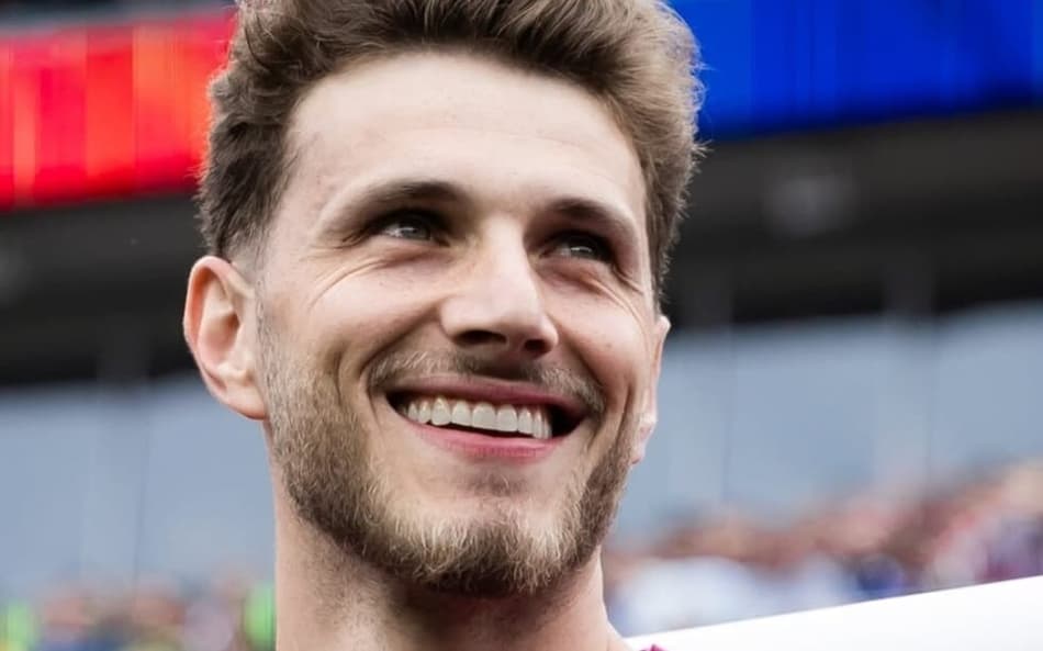Goleiro Bento olhando para cima e sorrindo, usando uma camisa da seleção brasileira na cor roxa.