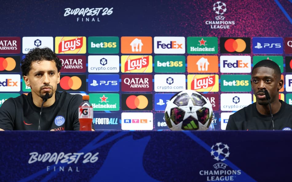 Marquinhos (à esquerda) e Dembélé (à direita) na coletiva de imprensa. Bola da final da Champions no centro