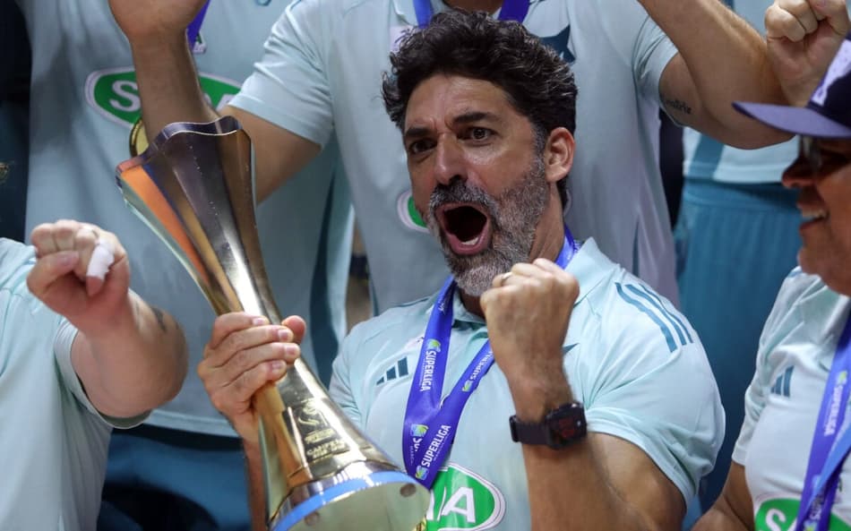 O técnico do Sada Cruzeiro, Filipe Ferraz, segura a taça da Superliga