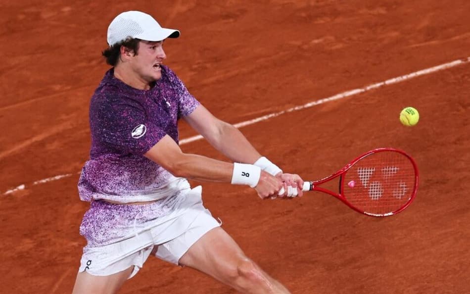 João Fonseca desliza para bater de esquerda contra o tcheco Jakub Mensik em Roland Garros (Foto: Anne-Christine POUJOULAT / AFP)