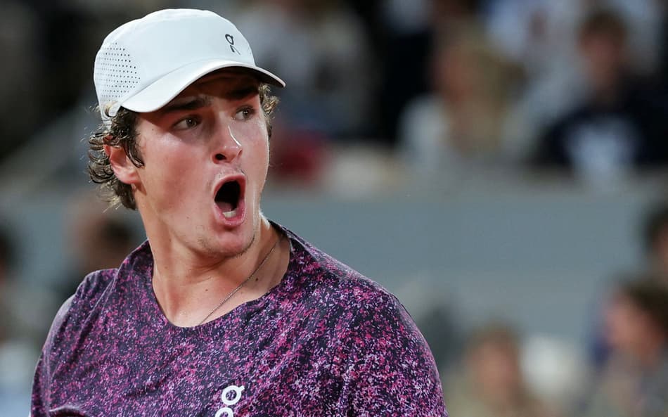 O brasileiro João Fonseca reage após um ponto em partida contra o tcheco Jakub Mensik pelas quartas de final de simples masculina no décimo dia do torneio de tênis de Roland Garros, na quadra Philippe-Chatrier, em Paris (Foto: Thomas Samson / Afp)