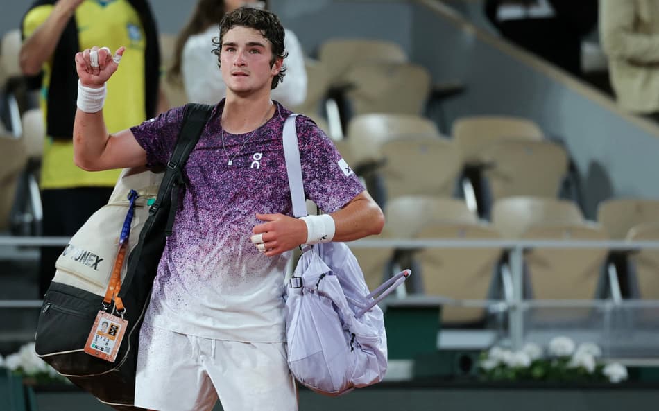 O brasileiro João Fonseca deixa a quadra após perder para o tcheco Jakub Mensik ao final da partida de quartas de final de simples masculina no décimo dia do torneio de tênis de Roland Garros, na quadra Philippe-Chatrier, em Paris (Foto: Thomas Samson / Afp)