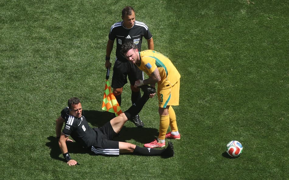 Felix Zwayer, árbitro de Estados Unidos x Austrália recebe ajuda de jogador no gramado após sofrer com cãibras