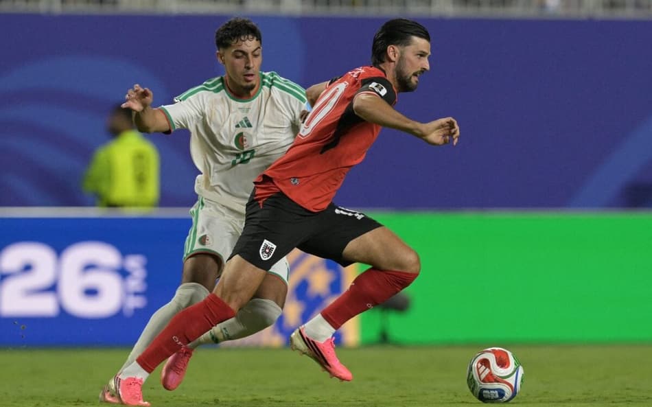O meio-campista da Argélia, Fares Chaibi (camisa 10), e o meio-campista da Áustria, Florian Grillitsch (camisa 10), disputam a bola durante a partida de futebol do Grupo J da Copa do Mundo de 2026 entre Argélia e Áustria, no Kansas City Stadium, em Kansas City, em 27 de junho de 2026. (Foto: JUAN MABROMATA / AFP)