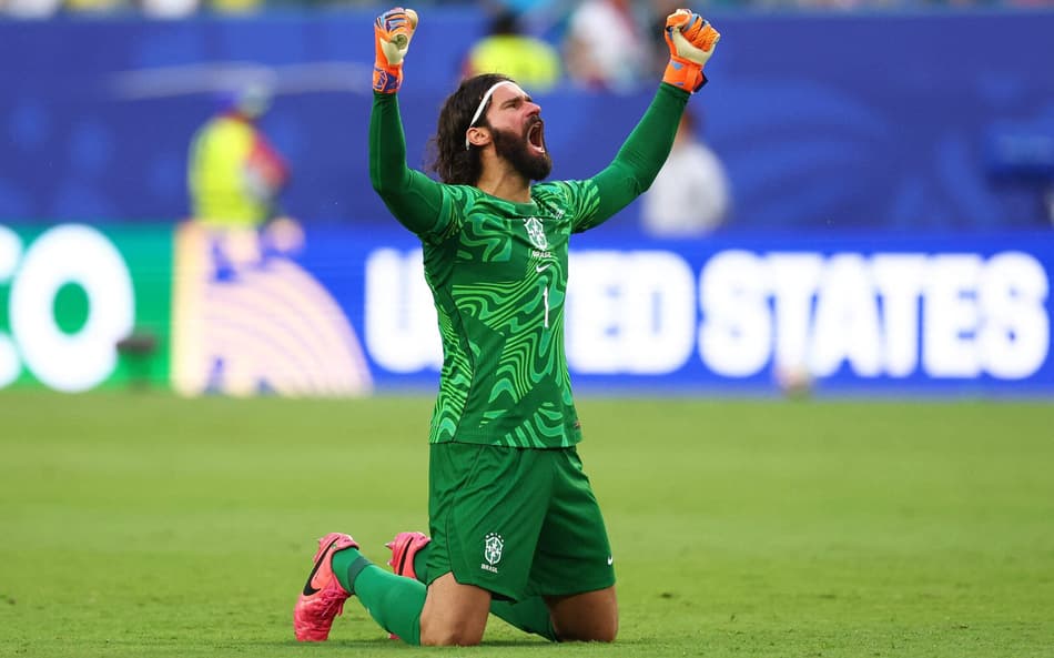 De joelhos, Alisson comemora gol do Brasil contra a Escócia