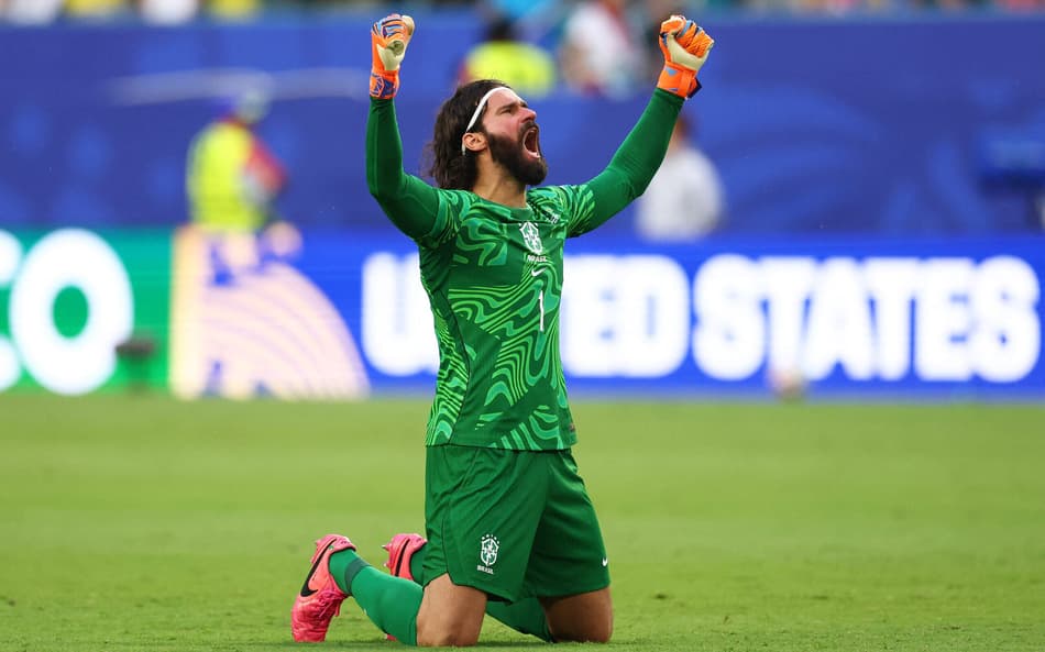 De joelhos, Alisson comemora gol do Brasil contra a Escócia