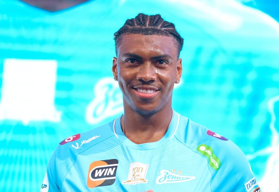 Felipe Augusto aponta para o escudo do novo clube