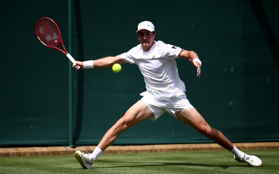 João Fonseca devolve a bola contra o espanhol Roberto Bautista Agut na estreia em Wimbledon