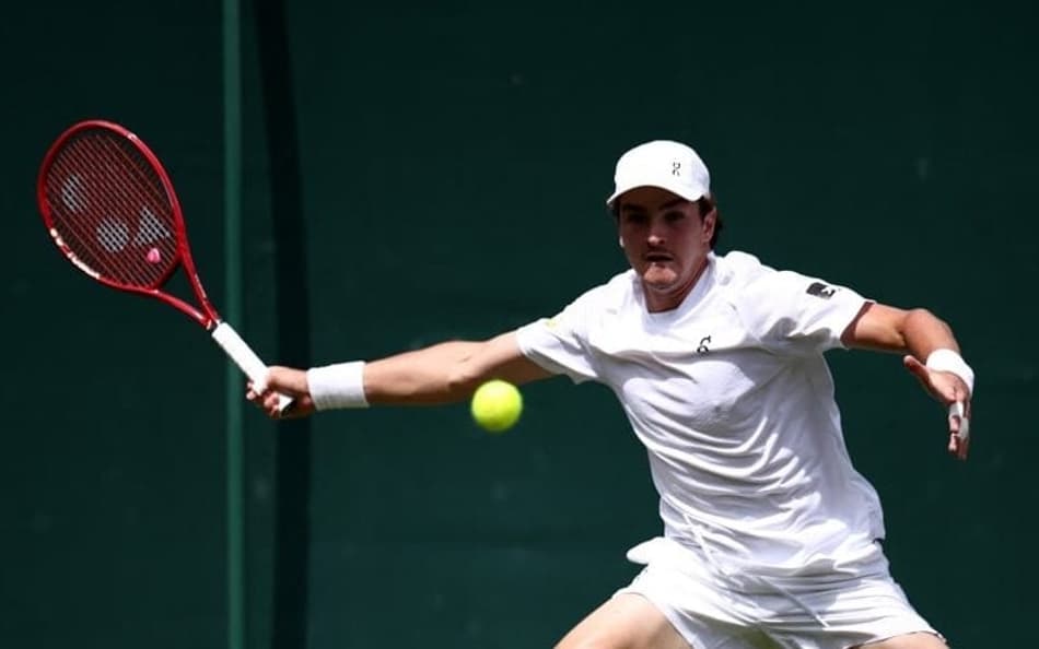 João Fonseca devolve a bola contra o espanhol Roberto Bautista Agut na estreia em Wimbledon