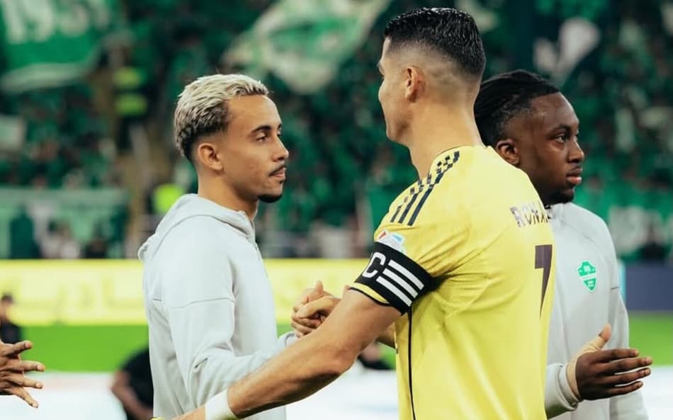 Matheus Gonçalves ao lado de Cristiano Ronaldo em partida do futebol saudita