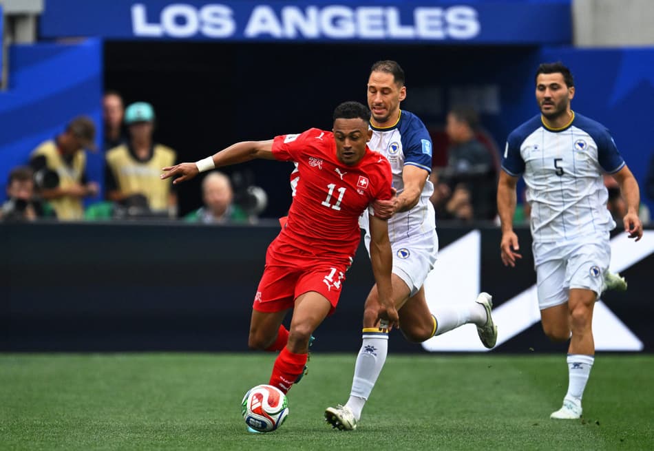 O atacante suíço Dan Ndoye corre com a bola além do zagueiro Nikola Katic da Bósnia-Herzegovina durante a partida do Grupo B da Copa do Mundo de 2026 entre Suíça e Bósnia e Herzegovina