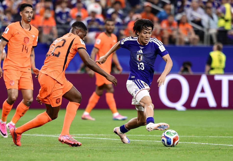 O meio-campista japonês Keito Nakamura disputa a bola com o zagueiro holandês Denzel Dumfries durante a partida do Grupo F da Copa do Mundo de 2026 entre Holanda e Japão