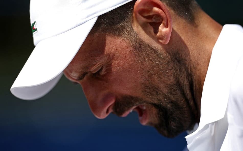 Sérvio Novak Djokovic olha para baixo em treino em Wimbledon