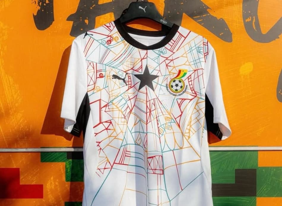 Camisa 2 da Seleção de Gana em um muro amarelo.