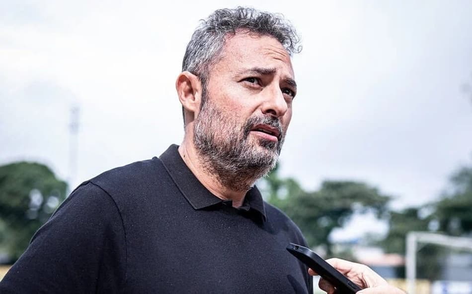 Alexandre Mattos de camisa preta dando entrevista