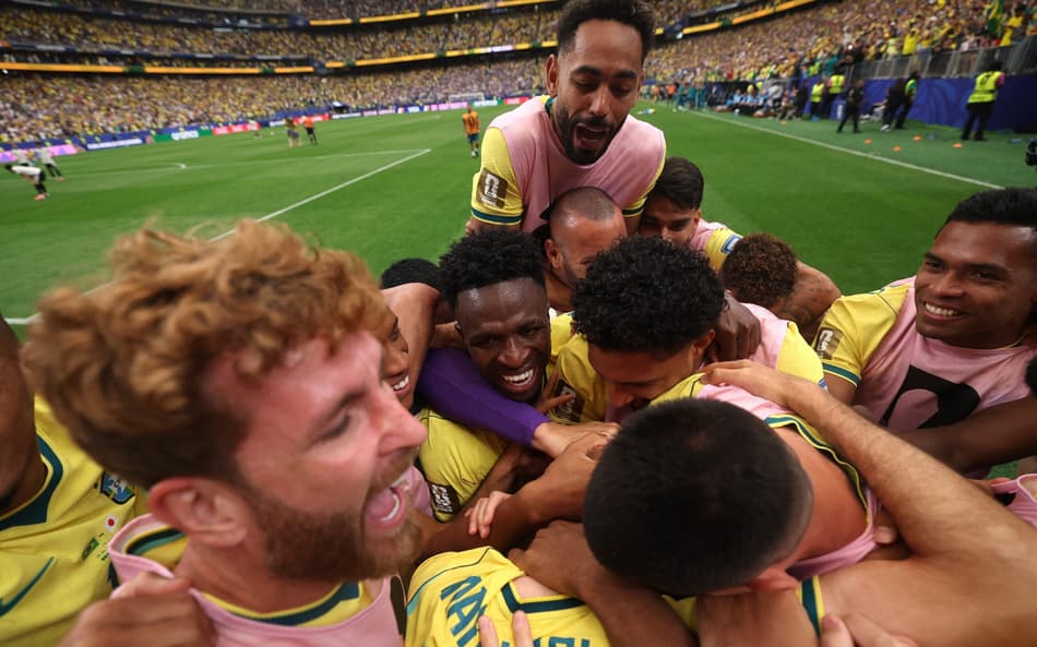 Matheus Cunha, Leo Pereira, Vini Jr, Alex Sandro e outros jogadores se abraçando após gol marcado
