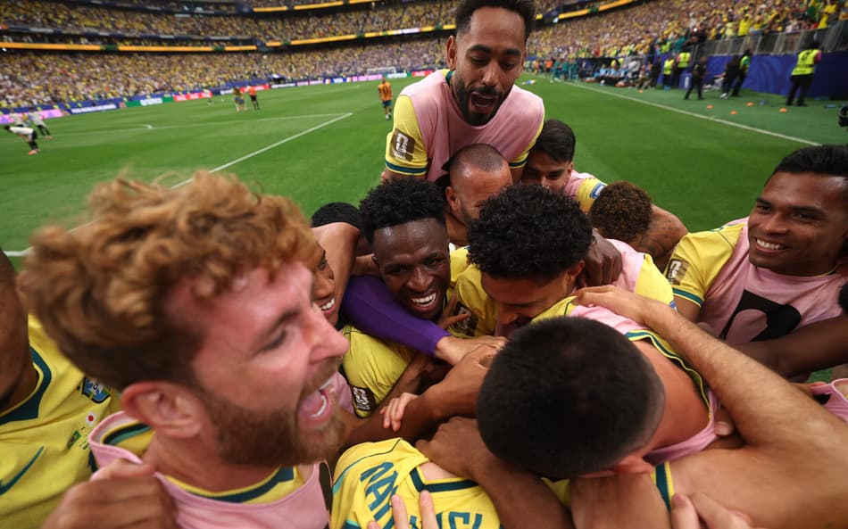 Matheus Cunha, Leo Pereira, Vini Jr, Alex Sandro e outros jogadores se abraçando após gol marcado
