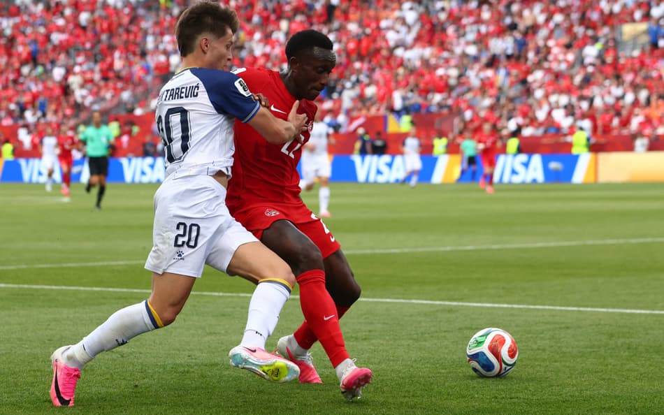 Esmir Bajraktarevic, da Bósnia, disputa bola com Richie Laryea, do Canadá, pela Copa do Mundo 2026 (Foto: Cole Burston / AFP)