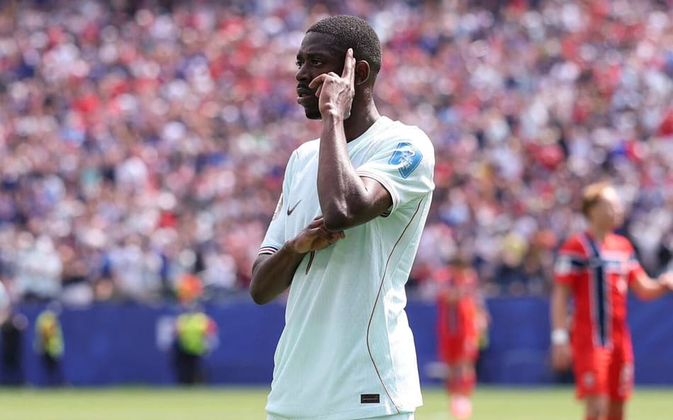 Dembélé, com a camisa branca da França, aponta para a própria cabeça na comemoração de um dos gols contra a Noruega