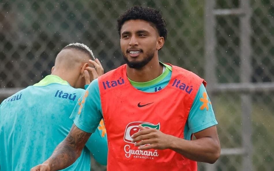 o volante Éderson se aquecendo com o colete laranja e uniforme verde de treino da seleção brasileira