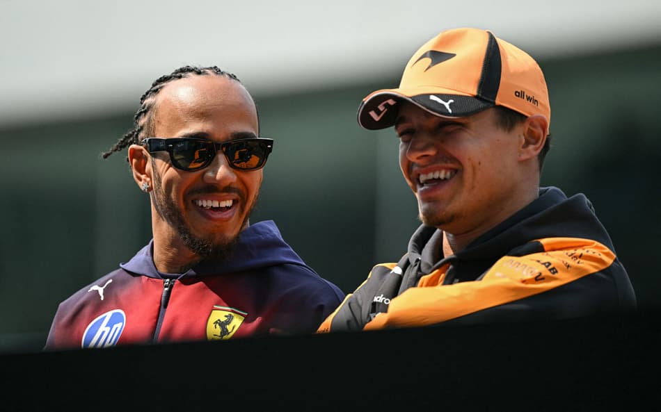 Lewis Hamilton e Lando Norris conversam durante o desfile dos pilotos antes do GP da China de Fórmula 1, em 15 de março de 2026. (Foto: Greg Baker/AFP)