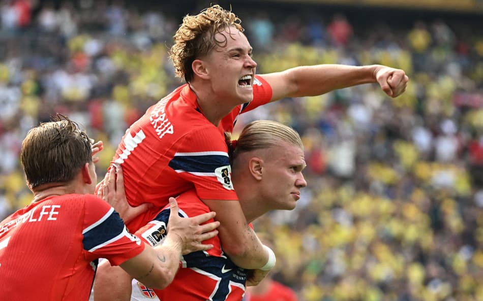 O atacante da Noruega, Erling Braut Haaland (à direita), comemora após marcar o primeiro gol de sua equipe com o seu companheiro de equipe, o meio-campista Andreas Schjelderup (nº 21), durante a partida de futebol das oitavas de final da Copa do Mundo de 2026 entre Brasil e Noruega, no New York/New Jersey Stadium, em East Rutherford