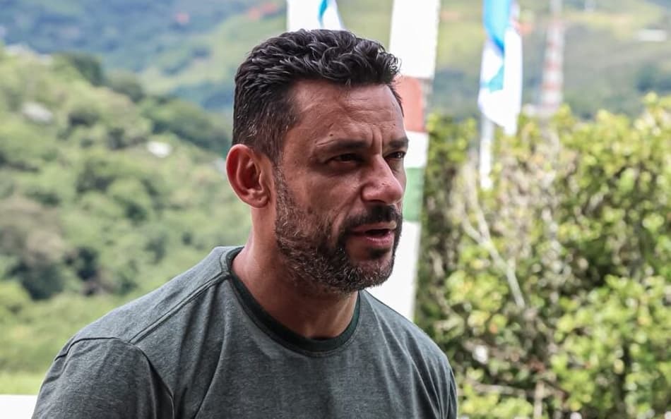 Anunciado como técnico do sub-20 do Fluminense, Fred olha para o lado de camisa cinza com a palavra "Xerém" e