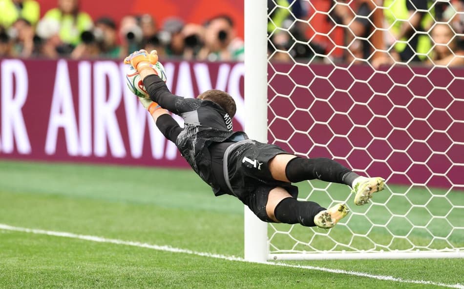 Goleiro suíço Gregor Kobel voa para defender a cobrança do colombiano Cucho Hernandez