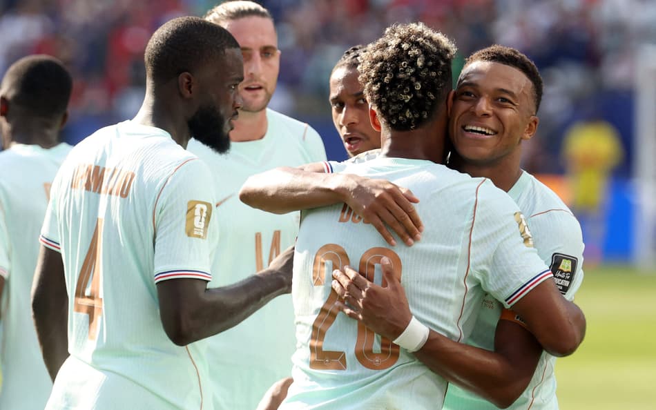 Jogadores da frança abraçados com Mbappé sorrindo
