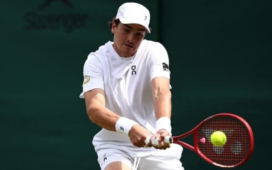 João Fonseca devolve de esquerda contra o espanhol Roberto Bautista Agut na estreia em Wimbledon