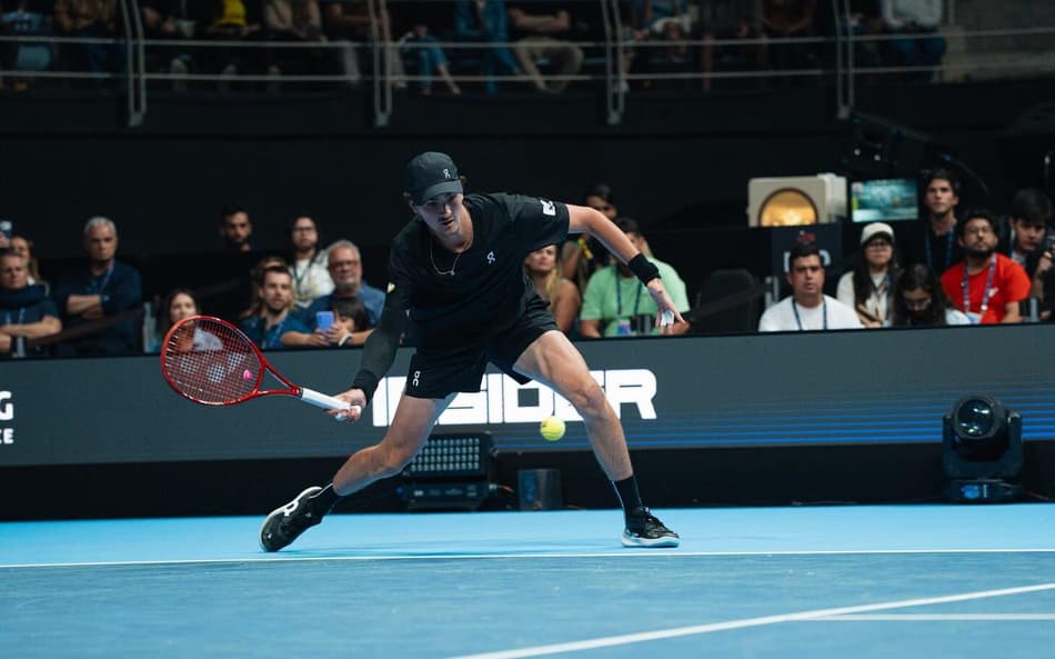João Fonseca se agacha para devolver a bola para o australiano Nick Kyrgios no UTS Rio