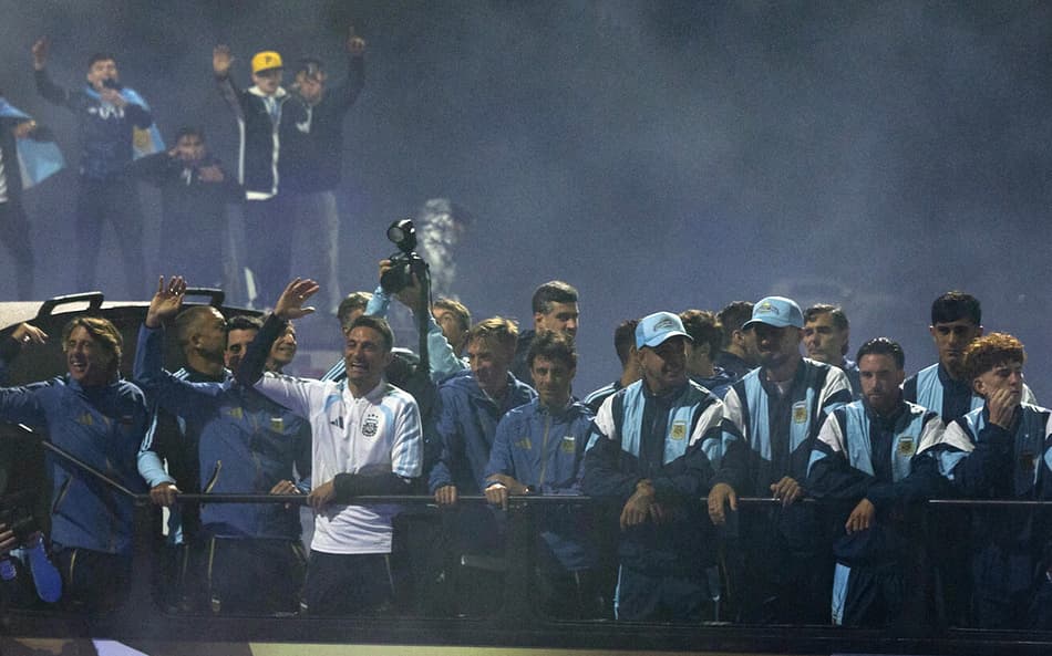 Lionel Scaloni, jogadores e membros da comissão técnica da Argentina acenam para torcedores a bordo de um ônibus aberto