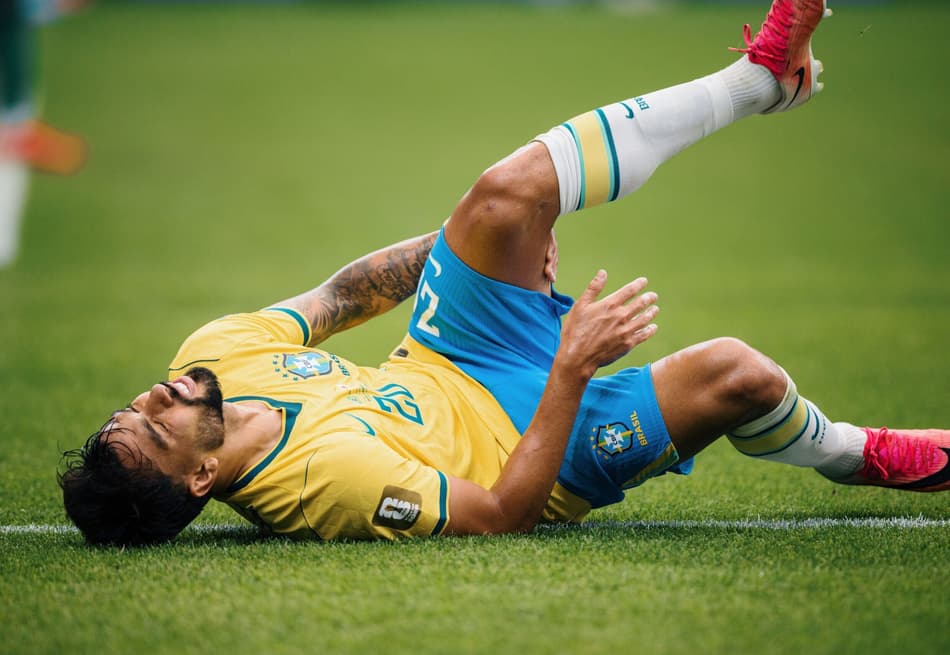 Lucas Paquetá leva a mão à coxa esquerda após sentir um incômodo no músculo posterior