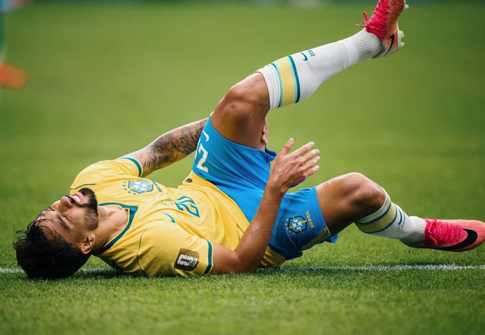 Lucas Paquetá leva a mão à coxa esquerda após sentir um incômodo no músculo posterior