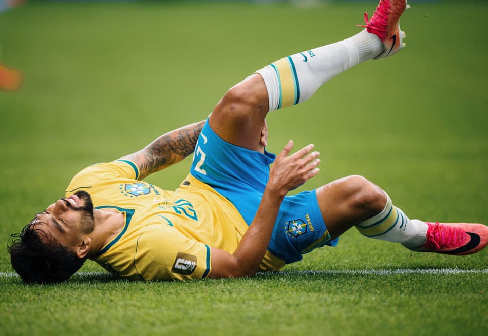 Lucas Paquetá leva a mão à coxa esquerda após sentir um incômodo no músculo posterior