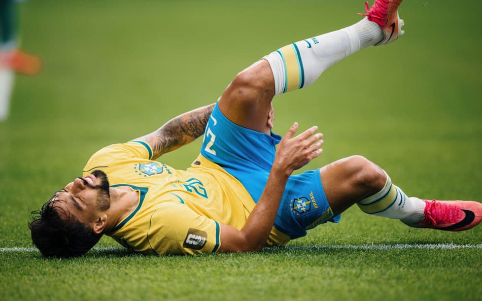 Lucas Paquetá leva a mão à coxa esquerda após sentir um incômodo no músculo posterior