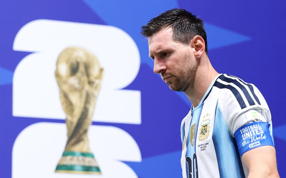 Messi passa próximo à cartaz com troféu da Copa do Mundo, vestindo camisa 10 da Argentina