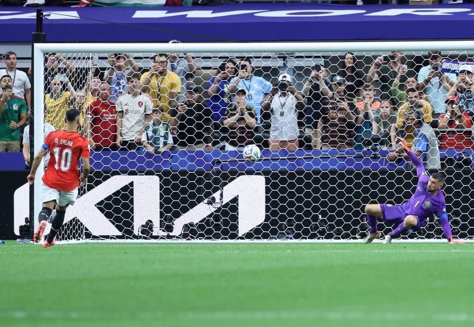 O atacante #10 do Egito, Mohamed Salah (Esquerda), chuta e marca ao passar pelo goleiro australiano #01 Mathew Ryan em uma disputa de pênaltis durante a partida dos 16 avos de final da Copa do Mundo de 2026 entre Austrália e Egito