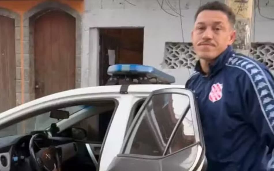 Zagueiro Luiz Gustavo, com casaco do Bangu, sendo preso